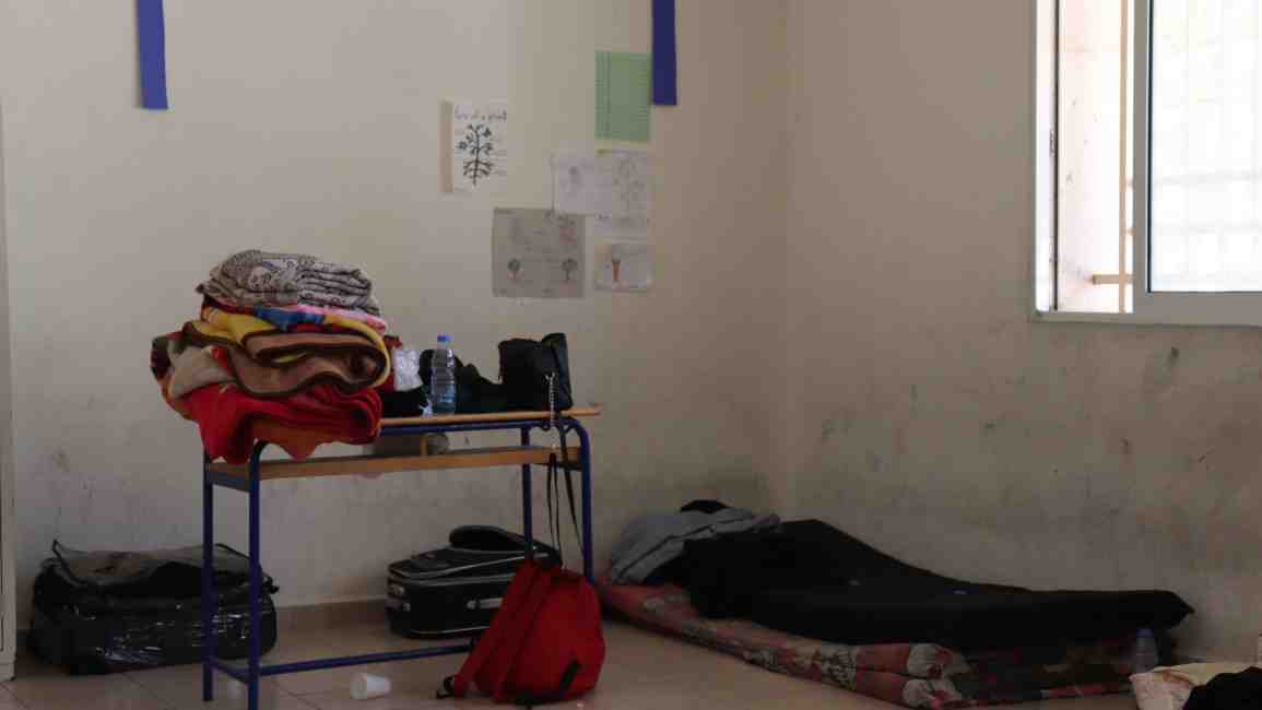 Desks are being used as storage decks as people try to make homes inside the foreign white walls