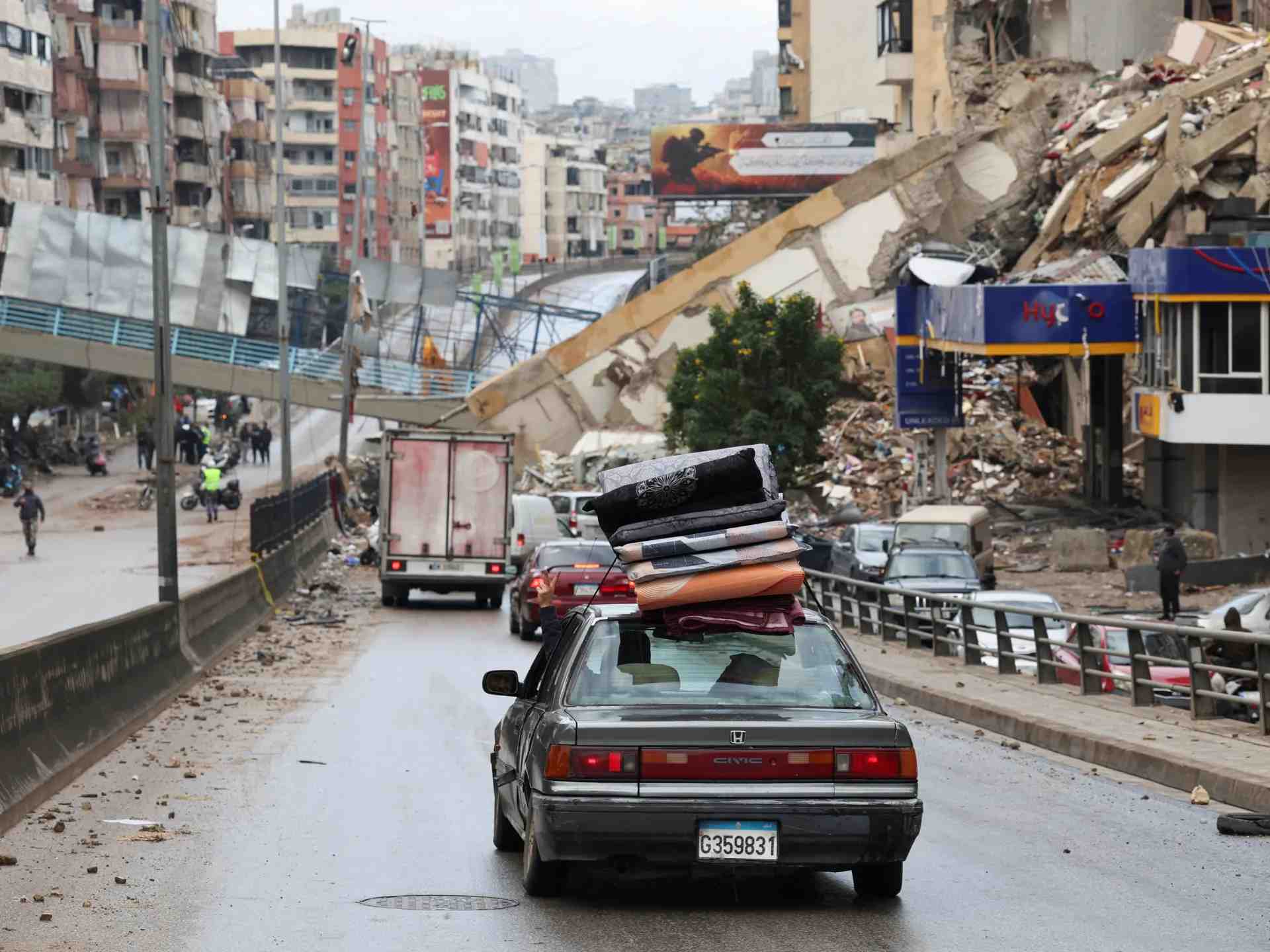 Car heading back home from displacement shelters amid rubble. (Image Credit: Al Jazeera)