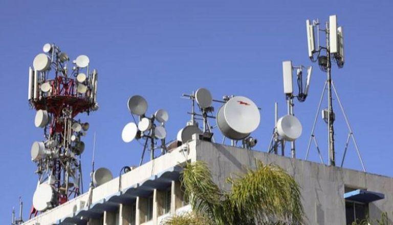 A rooftop crowded with various telecommunication antennas A rooftop crowded with various telecommunication antennas