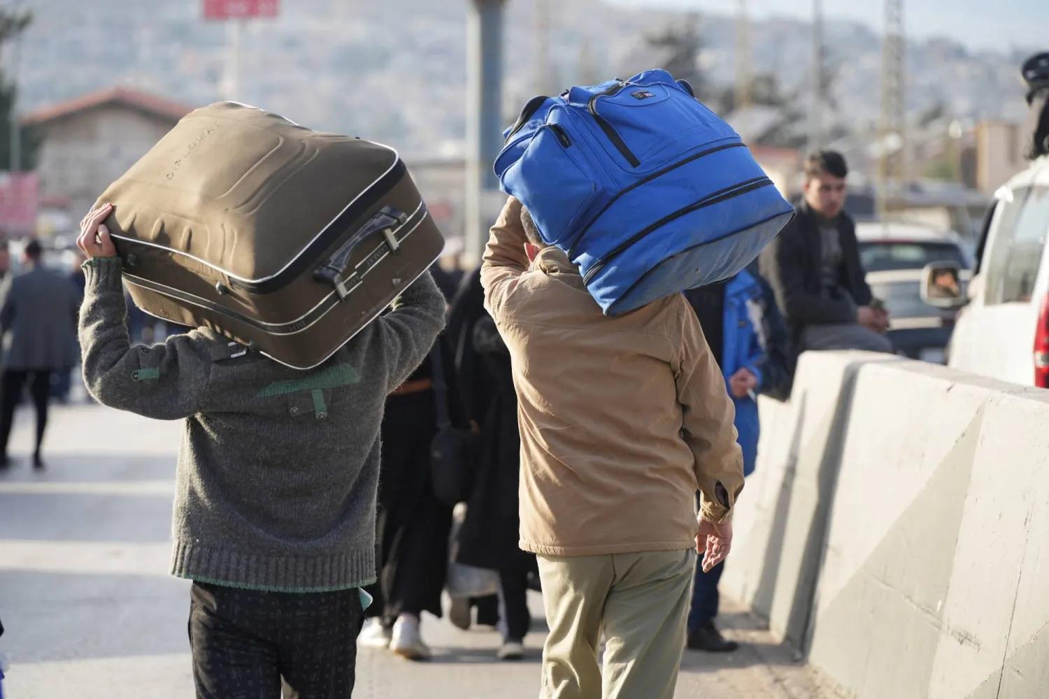 Syrian displaced people carry their belongings (Reuters). Syrian displaced people carry their belongings (Reuters).
