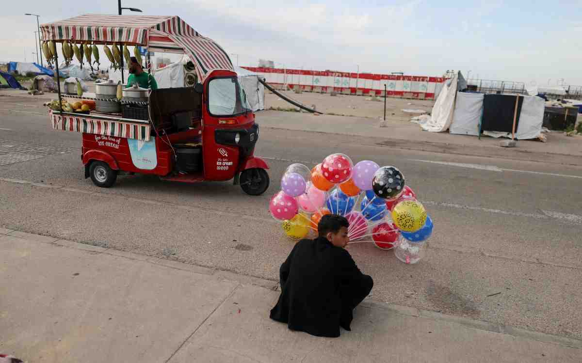 A displaced boy sells balloons as another displaced vendor sells food at a makeshift encampment, amid a temporary ceasefire between Lebanon and Israel, in Beirut, Lebanon, April 25, 2026. (Credit: Zohra Bensemra/ Reuters)