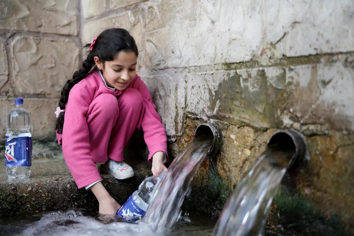 Young girl filling water bottles Young girl filling water bottles