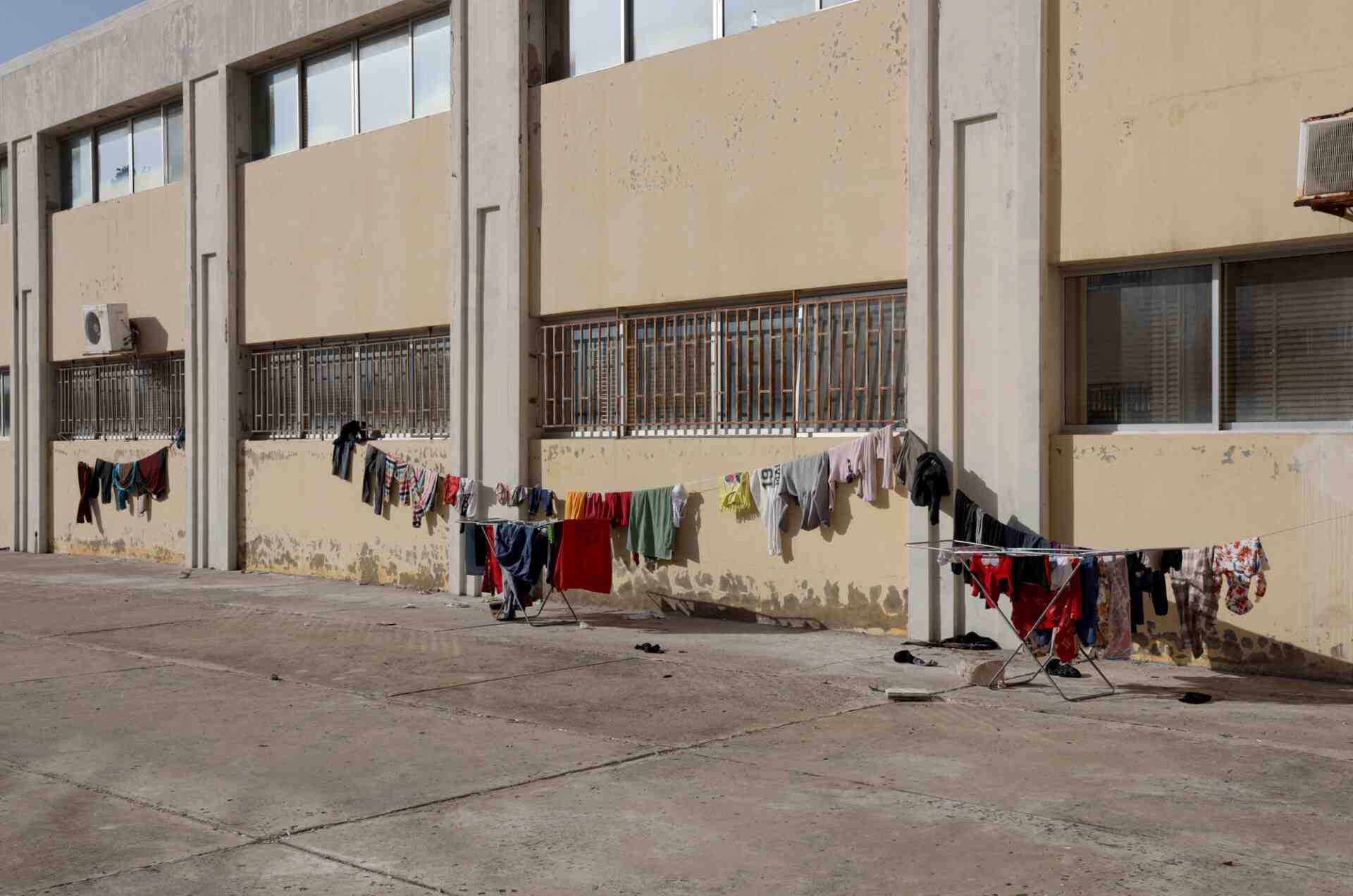 Colorful clothes hanging on lines in front of a shelter building