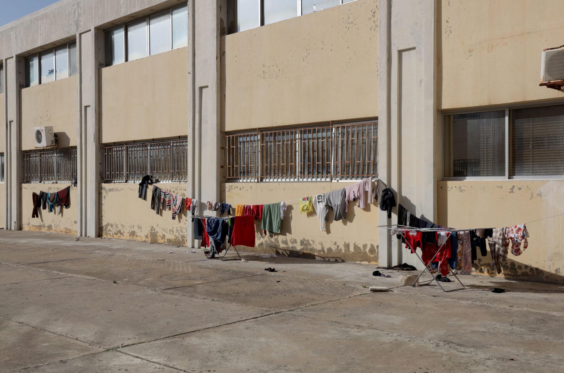 Colorful clothes hanging on lines in front of a shelter building Colorful clothes hanging on lines in front of a shelter building