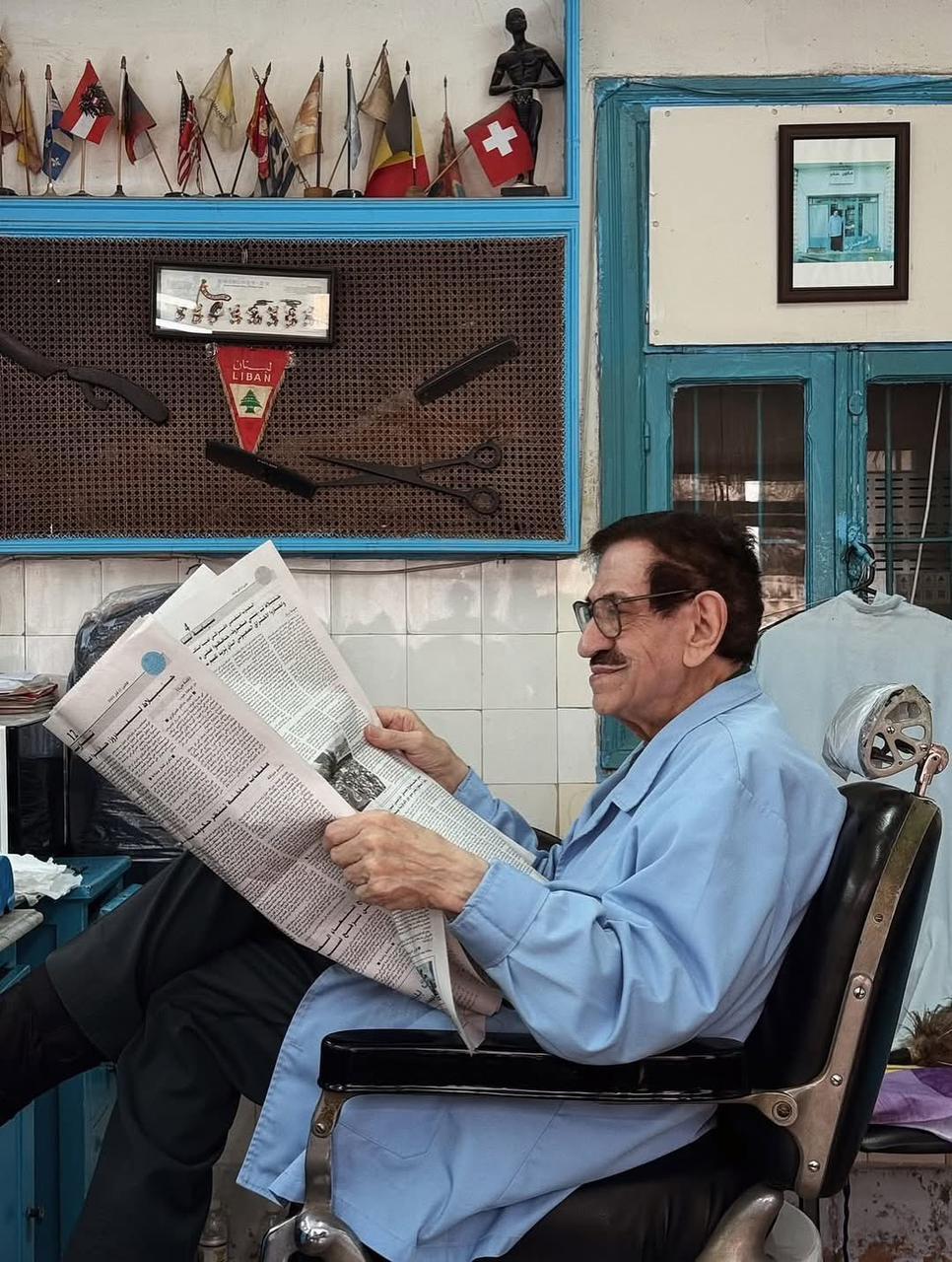 An older Lebanese barber sits comfortably on his chair in his shop An older Lebanese barber sits comfortably on his chair in his shop