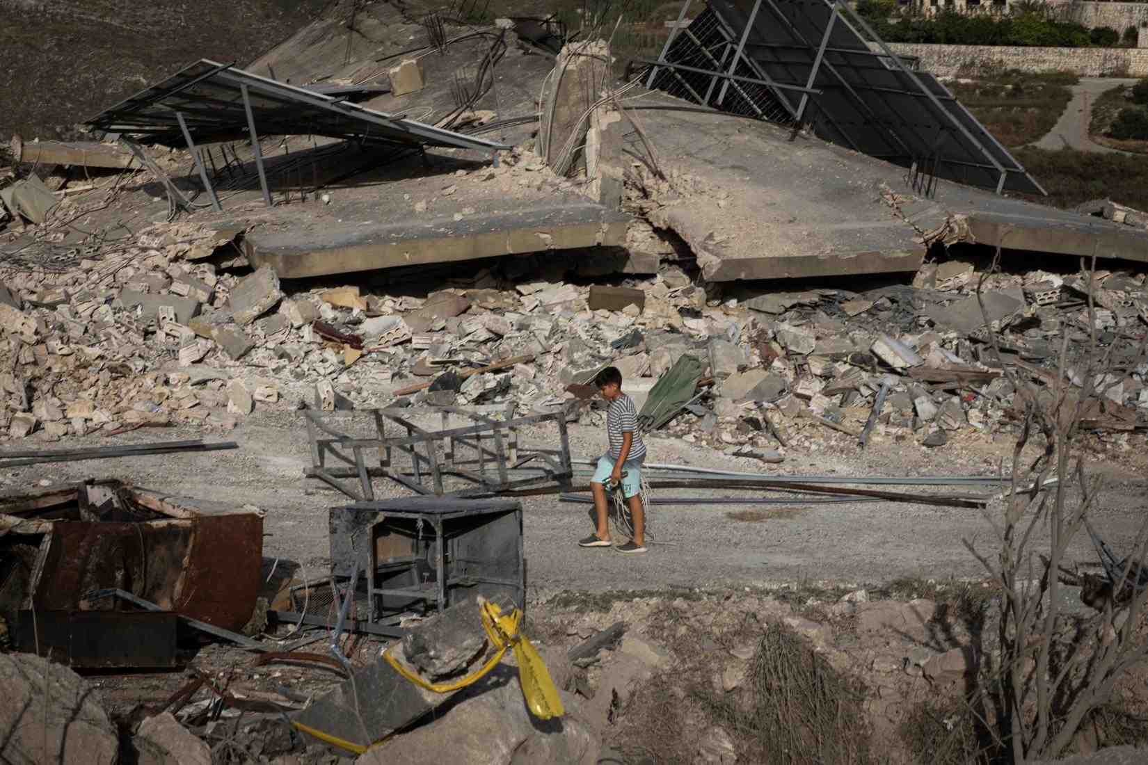 A child examines the ruin of his home. (Credit: UN Lebanon)