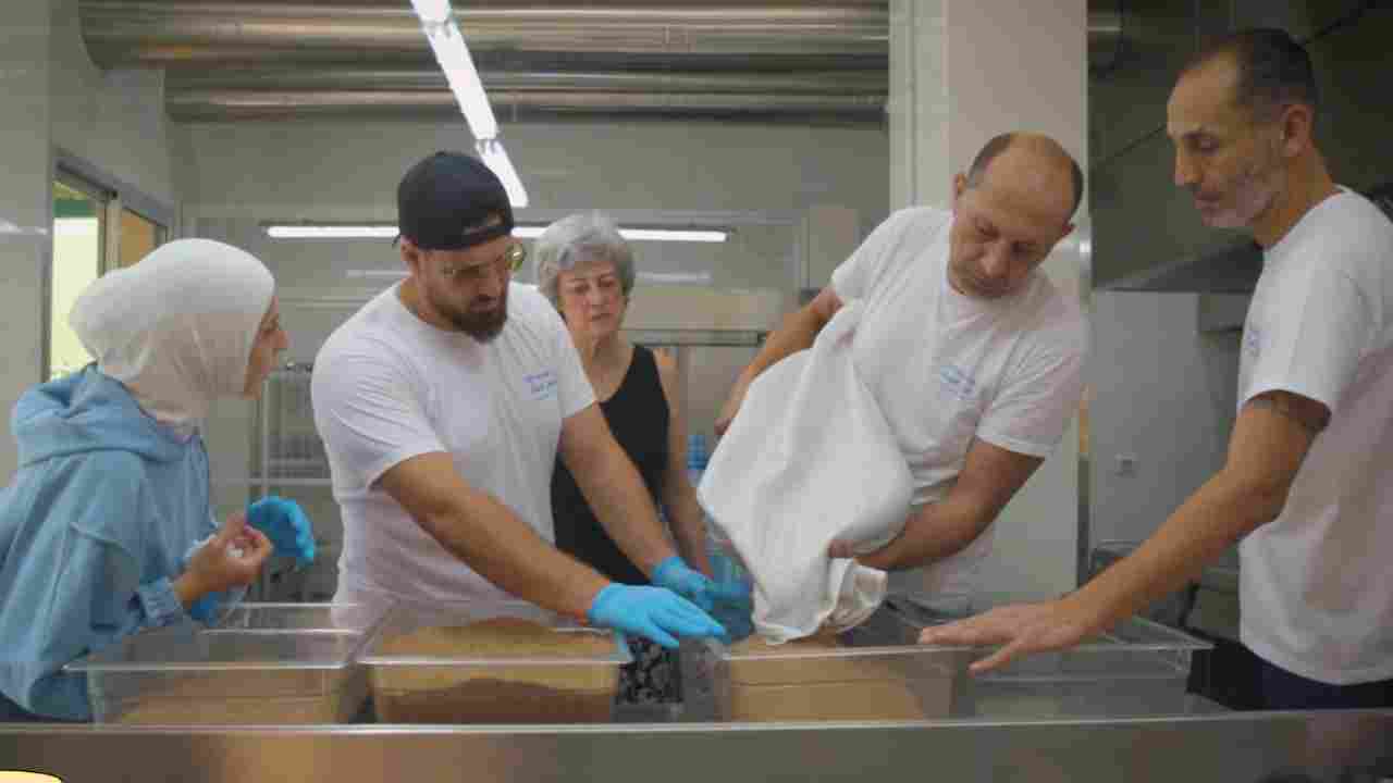 Volunteers preparing meals for displaced families in a community kitchen.