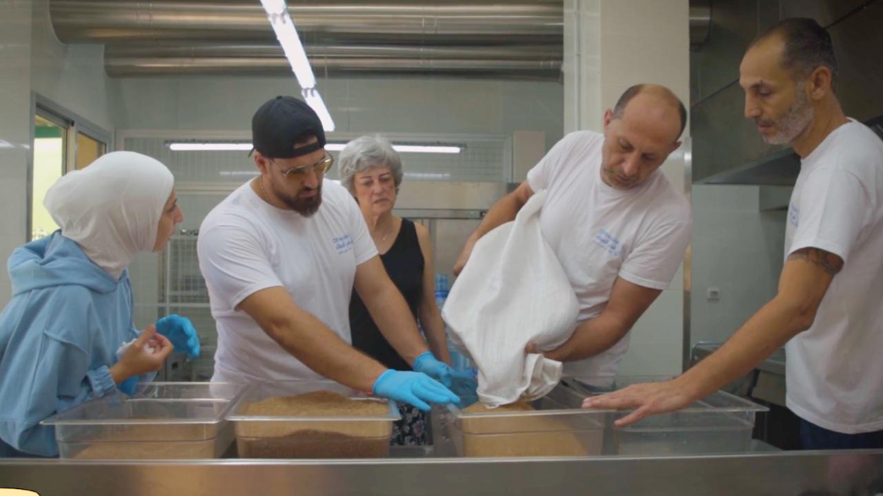 Volunteers preparing meals for displaced families in a community kitchen. Volunteers preparing meals for displaced families in a community kitchen.
