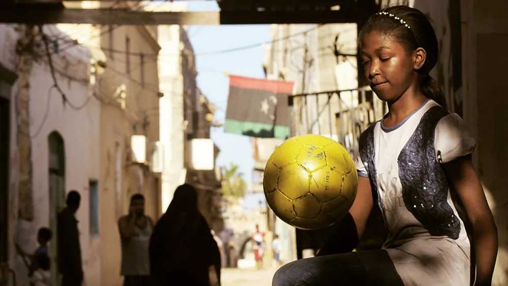 A woman plays football in the streets of Tripoli