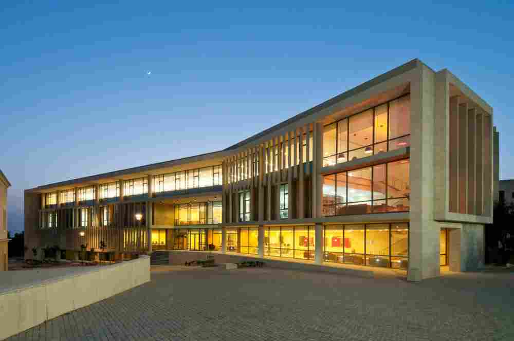 Modern university building at the University of Balamand in Lebanon, illuminated at dusk.