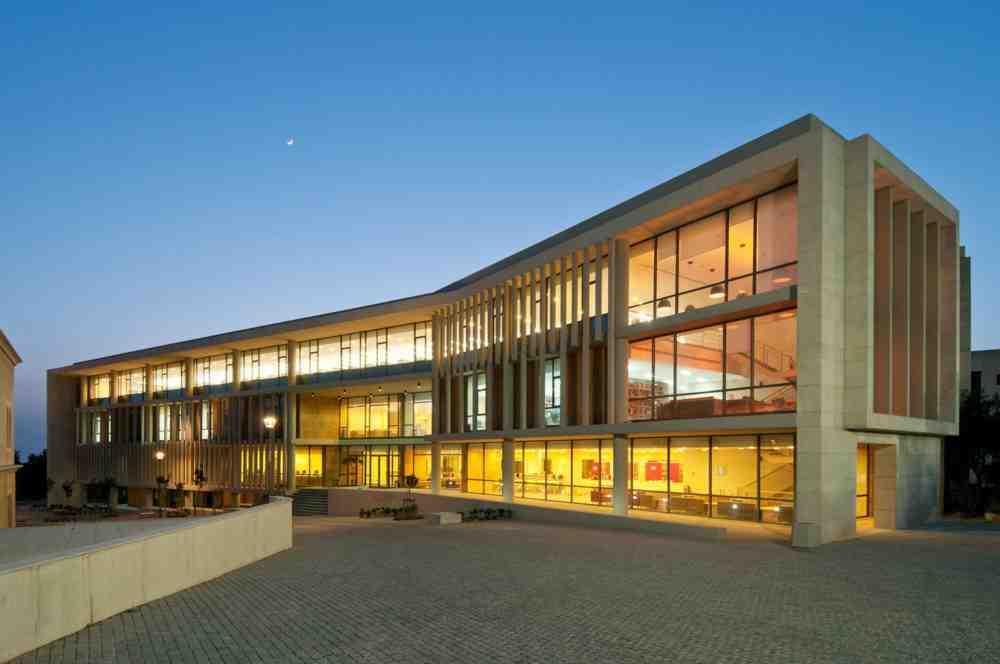 Modern university building at the University of Balamand in Lebanon, illuminated at dusk.
